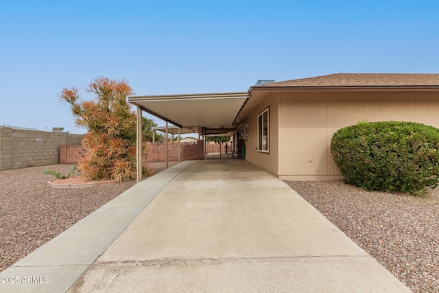 view of side of home featuring an attached carport and fence