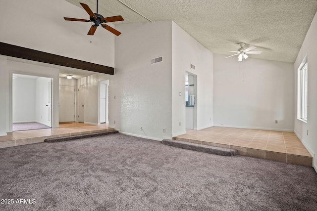 unfurnished living room with carpet floors, a ceiling fan, a textured ceiling, and visible vents
