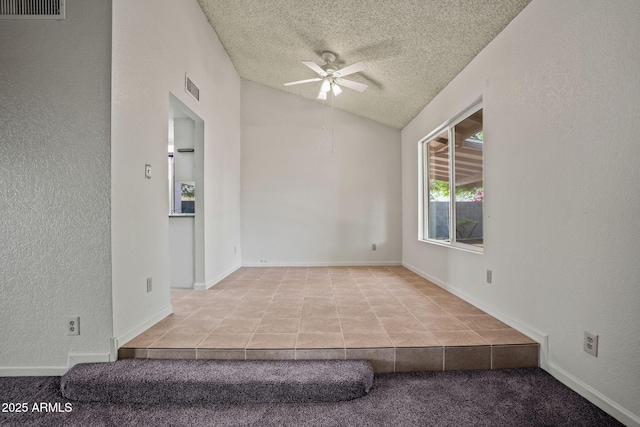 tiled spare room featuring ceiling fan, lofted ceiling, a textured ceiling, and visible vents
