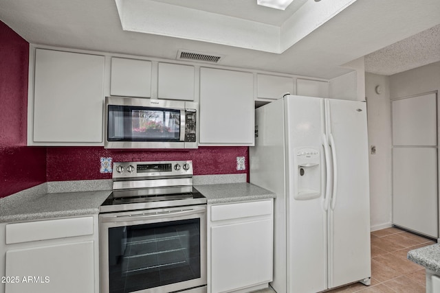 kitchen featuring visible vents, light countertops, appliances with stainless steel finishes, and white cabinets