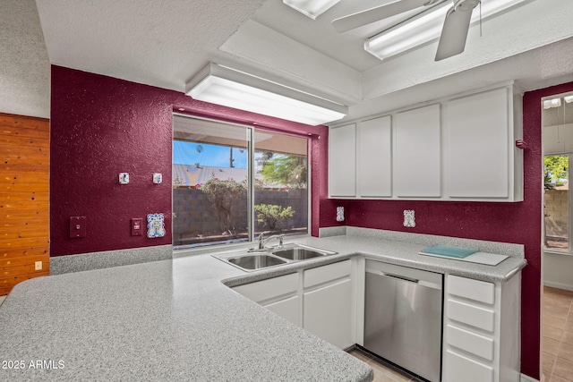 kitchen featuring a sink, dishwasher, white cabinets, and a healthy amount of sunlight