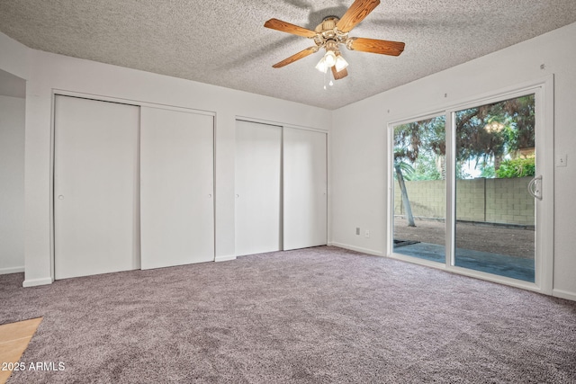 unfurnished bedroom featuring two closets, access to outside, and carpet flooring