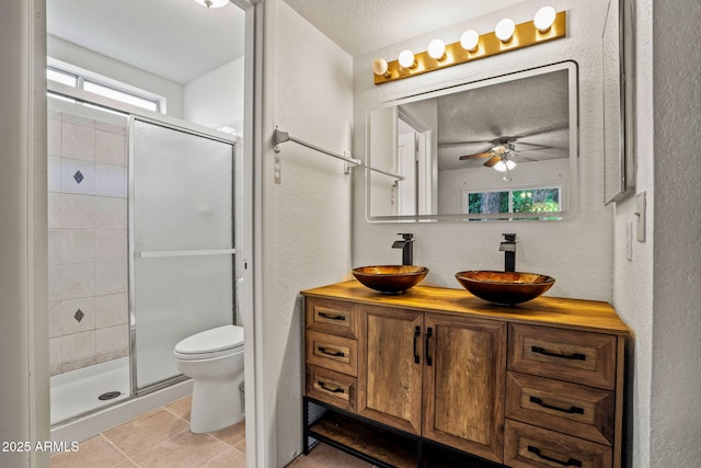 full bathroom featuring a sink, tile patterned floors, ceiling fan, and a shower stall