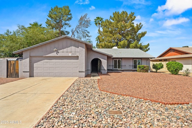 ranch-style home with a garage, fence, stucco siding, and concrete driveway