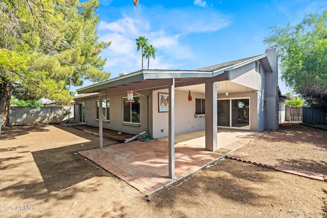rear view of house with a fenced backyard, a patio area, and brick siding