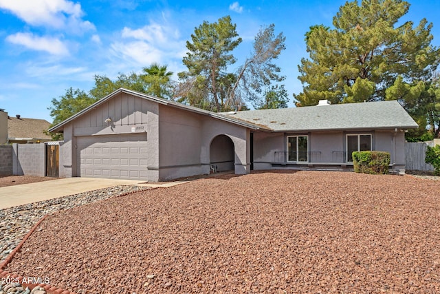 ranch-style house with fence, covered porch, an attached garage, and concrete driveway