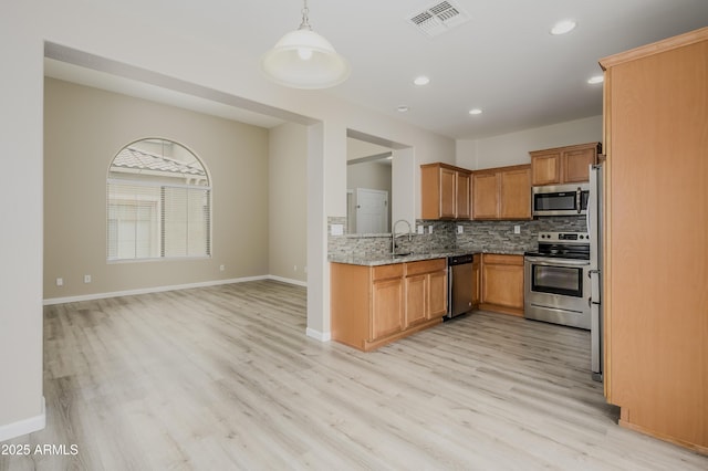 41715 N Raleigh Ct, Anthem, AZ 85086 - kitchen with stainless steel appliances, light stone countertops, light wood-type flooring, tasteful backsplash, and recessed lighting