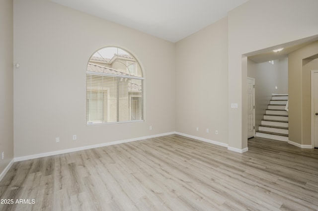 41715 N Raleigh Ct, Anthem, AZ 85086 - spare room featuring wood finished floors, baseboards, and stairs