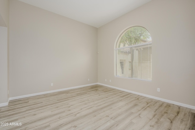 41715 N Raleigh Ct, Anthem, AZ 85086 - spare room featuring light wood-type flooring, baseboards, and lofted ceiling