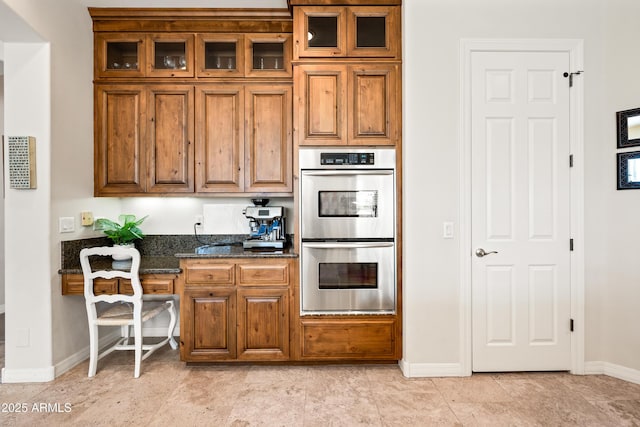 kitchen with double oven and dark stone countertops