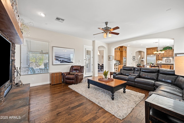 living room featuring dark wood-type flooring and ceiling fan with notable chandelier