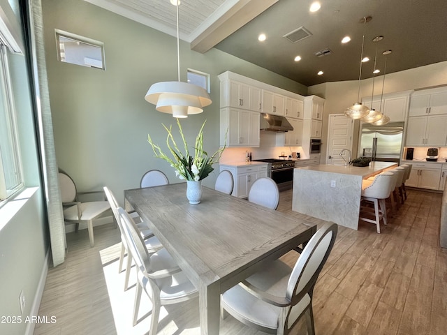 dining area with baseboards, visible vents, beamed ceiling, light wood-style floors, and recessed lighting