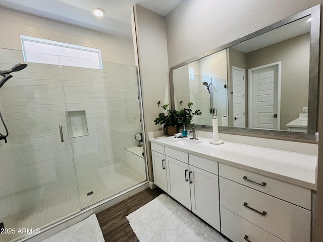 full bathroom featuring a stall shower, wood finished floors, and vanity