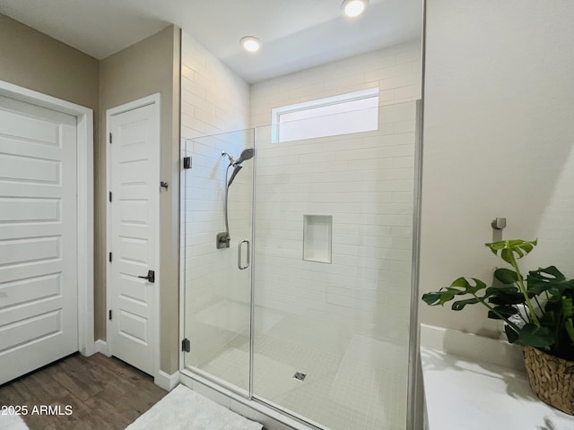 full bathroom with a stall shower and wood finished floors