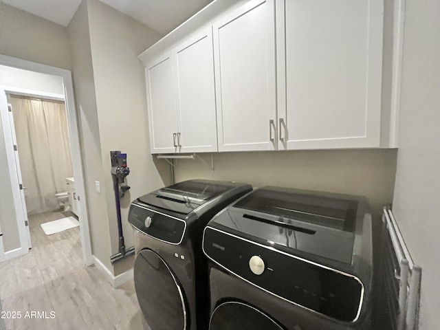 clothes washing area with cabinet space, baseboards, separate washer and dryer, and light wood finished floors