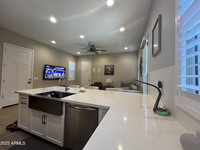 kitchen with light countertops, stainless steel dishwasher, a sink, and recessed lighting