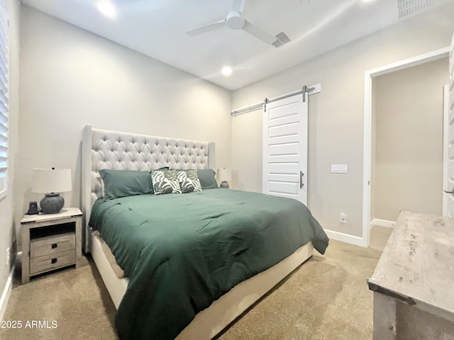 bedroom featuring visible vents, a barn door, a ceiling fan, light carpet, and baseboards