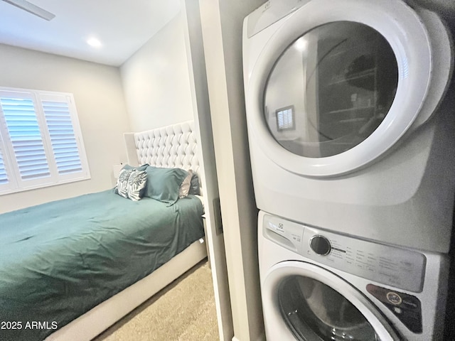 clothes washing area featuring stacked washer / drying machine and laundry area