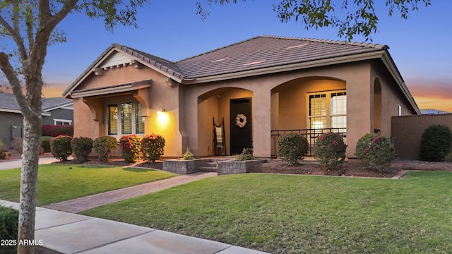20546 W Summit Pl, Buckeye, AZ 85396 - view of front of property with stucco siding, a yard, a tile roof, and covered porch