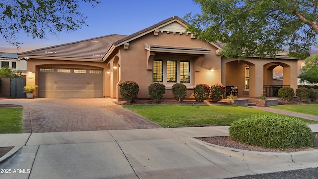 20546 W Summit Pl, Buckeye, AZ 85396 - mediterranean / spanish home with decorative driveway, stucco siding, an attached garage, and covered porch
