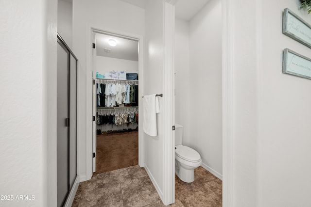 20546 W Summit Pl, Buckeye, AZ 85396 - bathroom featuring toilet, a spacious closet, and tile patterned floors
