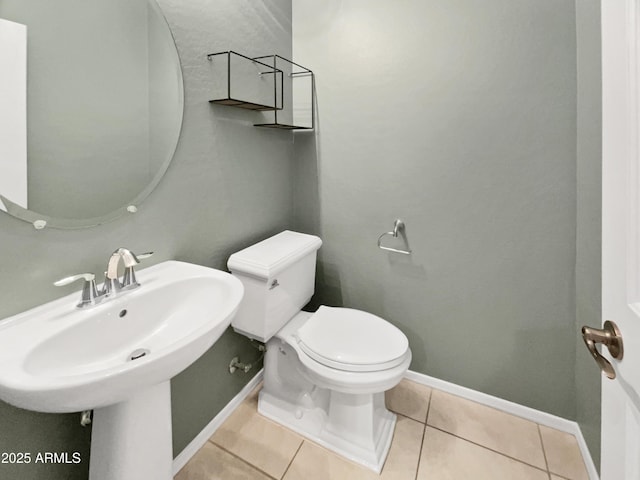 bathroom featuring toilet, tile patterned floors, and sink