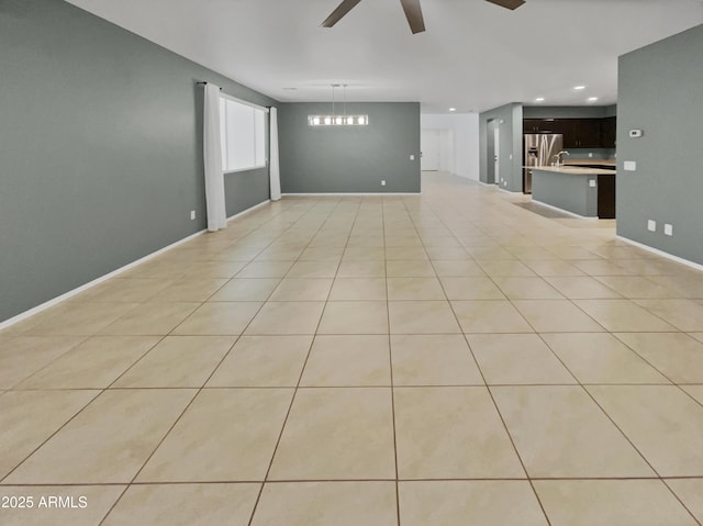 empty room with ceiling fan and light tile patterned floors