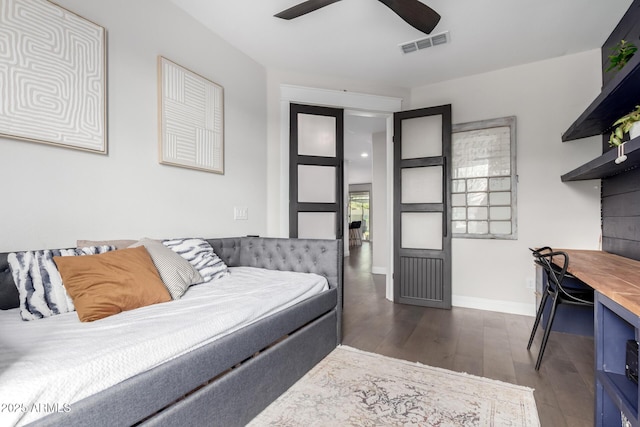 living area featuring visible vents, ceiling fan, baseboards, and wood finished floors