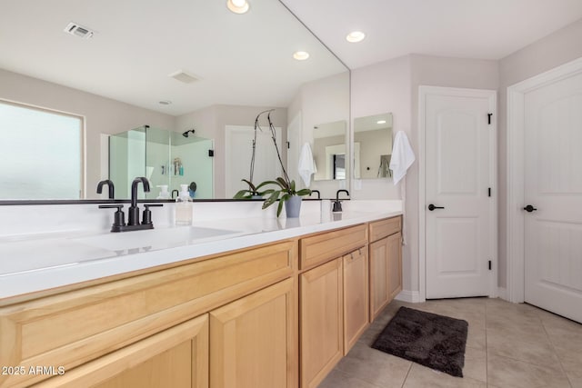 bathroom with double vanity, a stall shower, tile patterned flooring, a sink, and recessed lighting