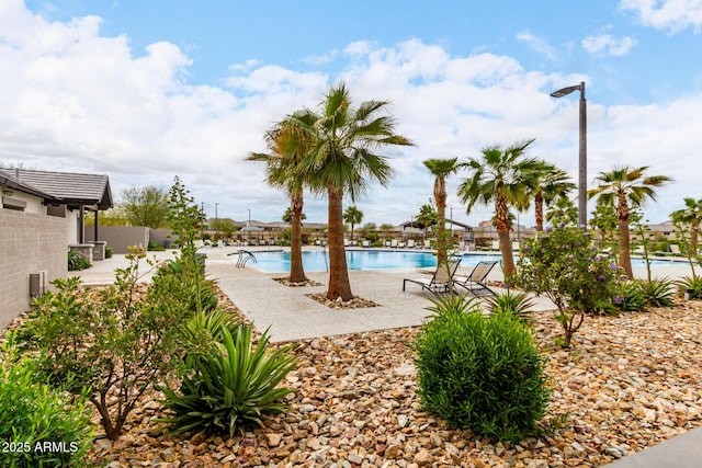 pool with a patio area and fence