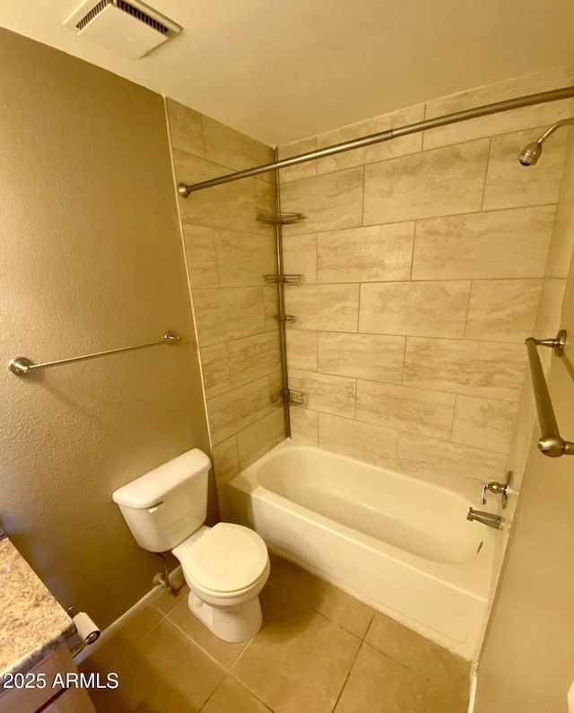 bathroom with tiled shower / bath, tile patterned floors, and toilet