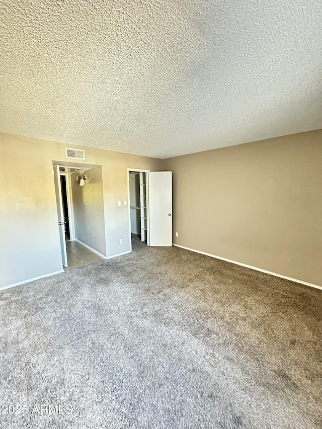 unfurnished bedroom featuring carpet, a textured ceiling, and a closet