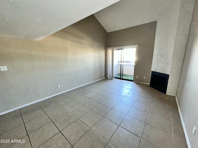 unfurnished living room with vaulted ceiling and light tile patterned floors