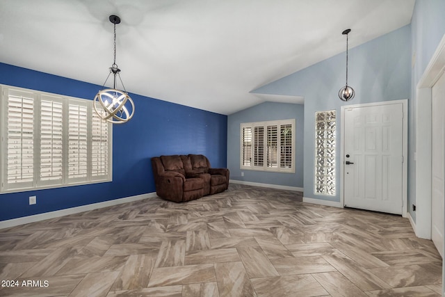 foyer featuring vaulted ceiling, a healthy amount of sunlight, a notable chandelier, and baseboards