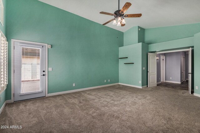 carpeted spare room with ceiling fan and high vaulted ceiling