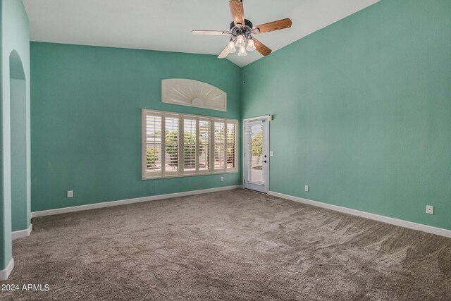 carpeted spare room featuring ceiling fan and vaulted ceiling