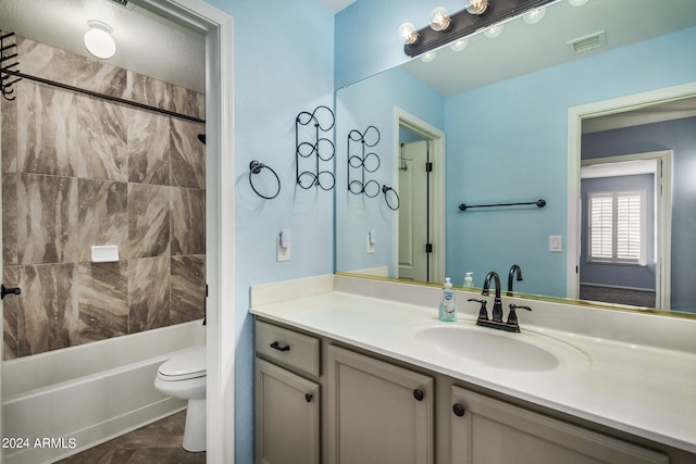 full bathroom featuring vanity, tiled shower / bath combo, toilet, and tile patterned flooring