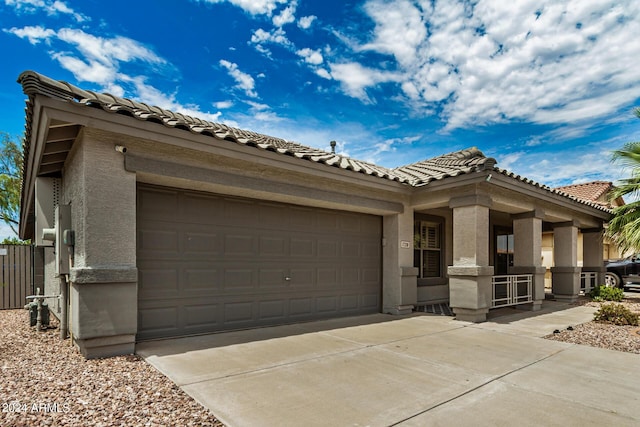 mediterranean / spanish-style home with driveway, an attached garage, a tiled roof, and stucco siding