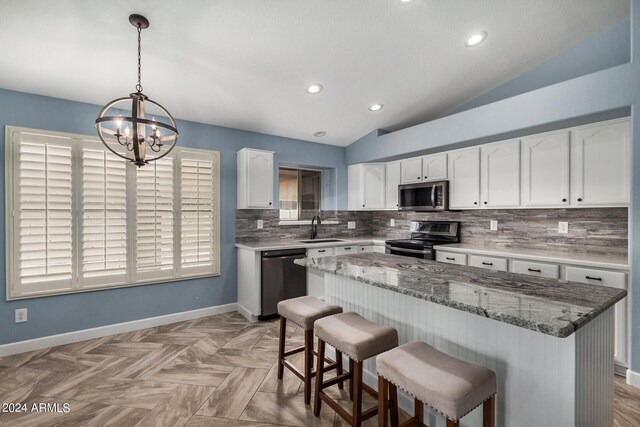 kitchen featuring decorative backsplash, white cabinets, stainless steel appliances, and sink