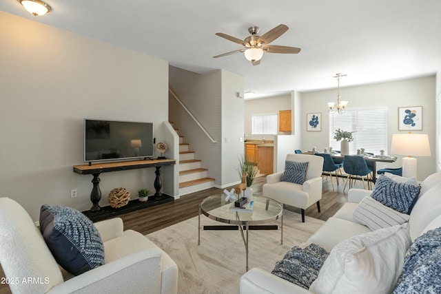 living room with hardwood / wood-style flooring and ceiling fan with notable chandelier