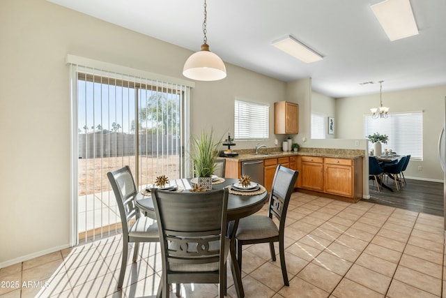 tiled dining room with sink and a chandelier