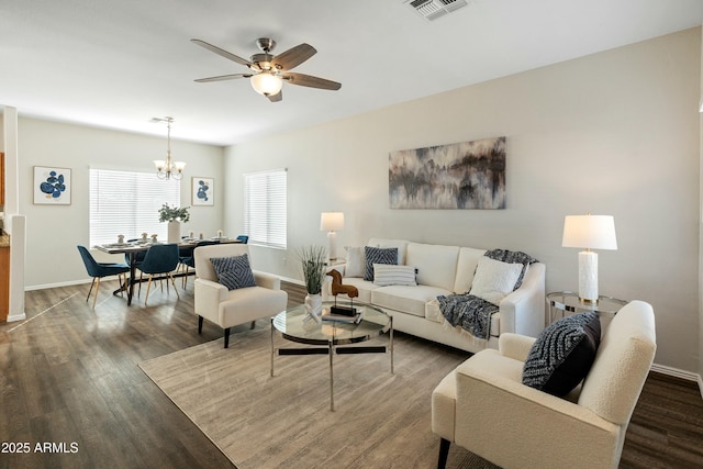 living room featuring dark hardwood / wood-style flooring and ceiling fan with notable chandelier