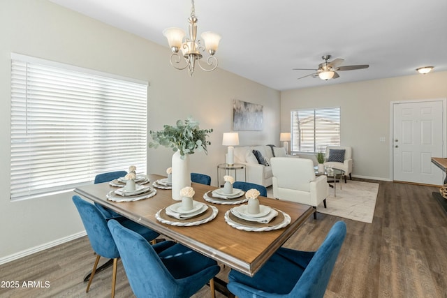 dining room featuring dark hardwood / wood-style flooring and ceiling fan with notable chandelier