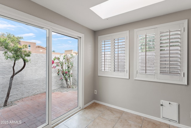 doorway to outside featuring a skylight and baseboards