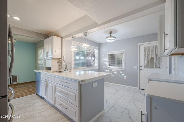 kitchen featuring stainless steel dishwasher, white cabinets, sink, and pendant lighting