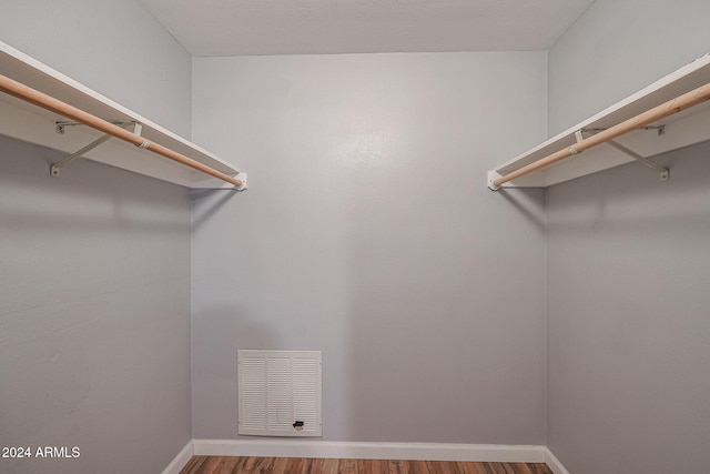 walk in closet with wood-type flooring