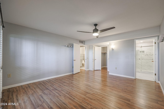 unfurnished bedroom with connected bathroom, ceiling fan, hardwood / wood-style flooring, and a closet