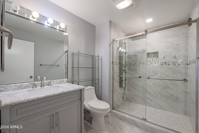 bathroom featuring a shower with door, vanity, and toilet