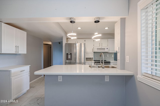 kitchen featuring white cabinets, tasteful backsplash, pendant lighting, and stainless steel fridge