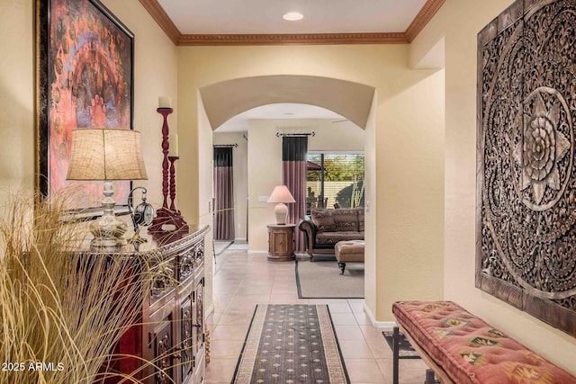 corridor with light tile patterned flooring, baseboards, arched walkways, and ornamental molding